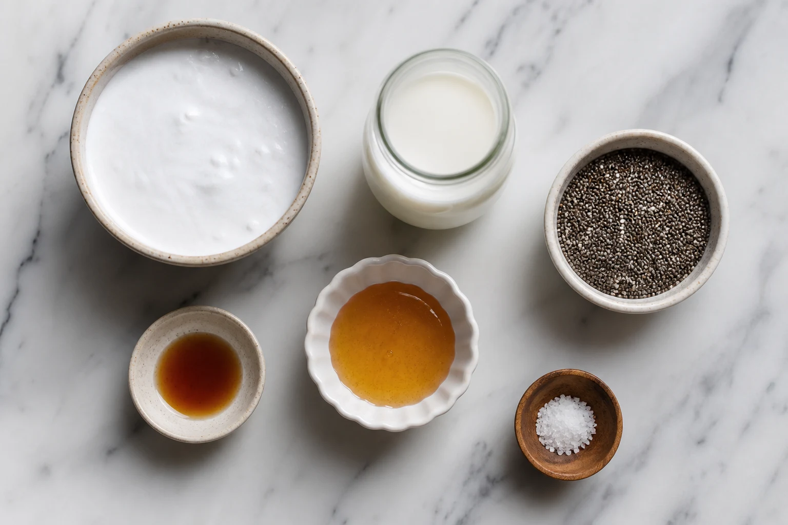 coconut milk ingredients, chia seeds, milk, sweetener, vanilla and salt arranged in a clean flat-lay.