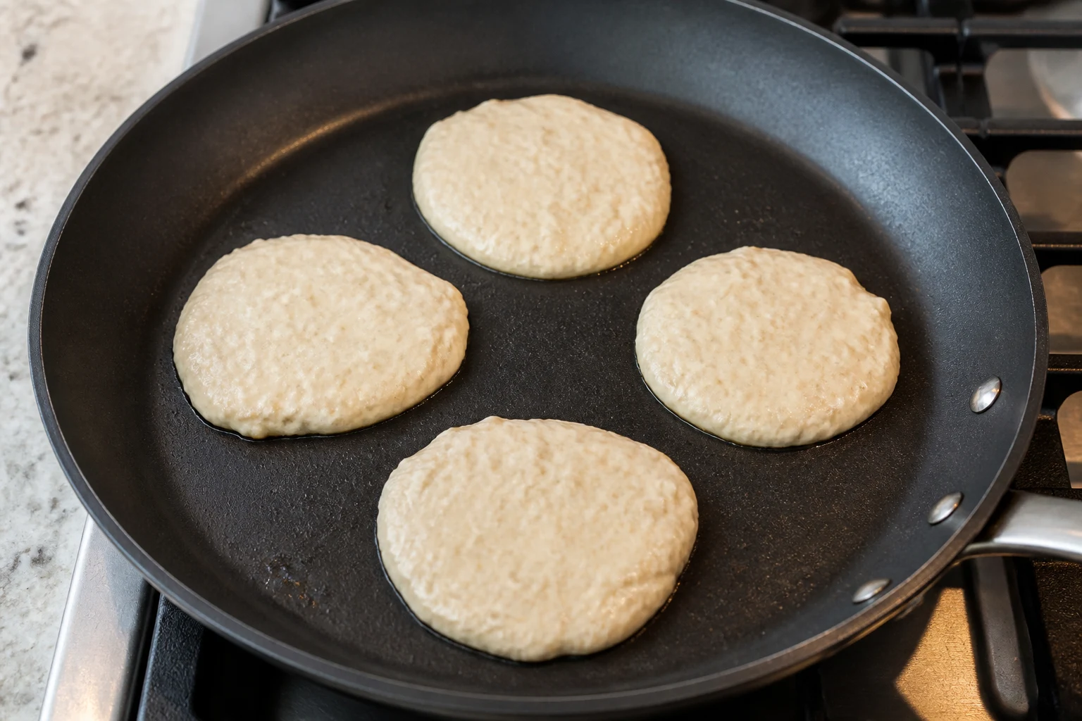 Thick blended oat and cottage-cheese pancake batter portioned onto a lightly greased skillet.
